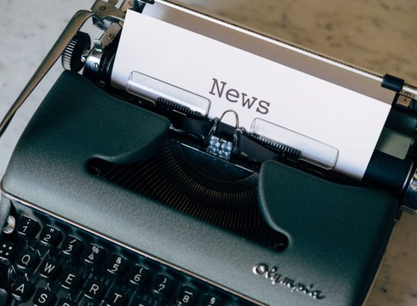 Close-up of a typewriter with a sheet of paper that has the word "News" on it.